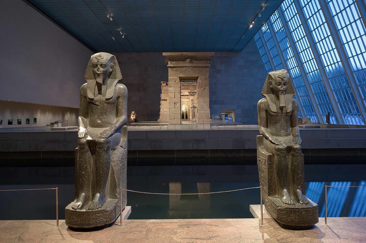 A view of the Temple of Dendur at The Met Fifth Avenue with two statues of pharaohs on either side